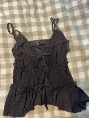 Going out top  - Selling this super pretty black going out top it’s covered in layers of ruffles and it is ruched in the places around the whole thing so it is stretchy, two ties in the front to open and close it. I’ve only worn it a couple times but the strap on one side is broken but I’ve sewn it back and worn it after there is also a minor stain on the back of one of the front ruffles, so not visible when you wear it🦭🦭 also just wanna say that it says XL but definitely fits as an S🦄