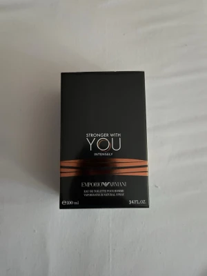 Stronger With You Intensely parfym - Stronger With You Intensely från Emporio Armani är en parfym i en elegant svart förpackning med kopparfärgade detaljer. Flaskan rymmer 100 ml och har en modern, stilren design som passar perfekt för dig som gillar exklusiva dofter.