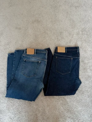 Acne Studios(Blå Konst) jeans - Tja, jag säljer två par Acne Studios Blå Konst jeans i olika blå tvättar. Klassisk femficksmodell med raka ben och normal midja. Snygga detaljer och robust denimkvalitet. Perfekta för dig som gillar stilrena och tidlösa jeans.