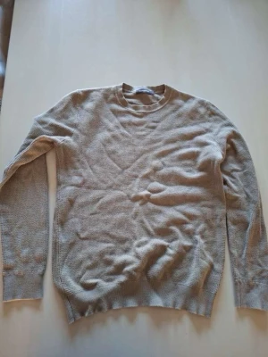 Beige stickad tröja från Dressmann - Säljer en beige stickad tröja från Dressmann i storlek M. Tröjan har rund halsringning, lång ärm och ribbade muddar vid ärmslut och nederkant. Materialet är mjukt och har en diskret struktur som ger en stilren look.