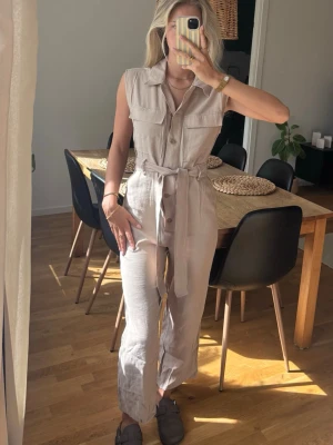 Jumpsuit - Jumpsuit i lyocell blend med fickor, knappar och knyte i midjan. 
