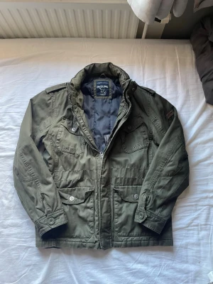Militär jacka - Snygg olivgrön militär/vindjacka från Crafted goods. Jackan har dragkedja, och tryckknappar! Skit fet men säljer för den är lite lite för stor, hör av er med frågor osv😌✌🏼