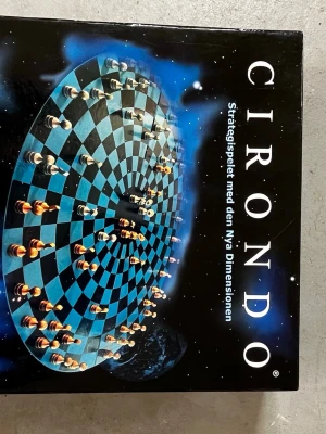 Brädspelet Cirondo  - Säljer brädspelet Cirondo, ett strategispel med en unik rund spelplan och schackliknande pjäser. Spelet har ett rymdtema på förpackningen och kan spelas av 2 eller 4 personer. Regler och illustrationer finns på baksidan av lådan. Perfekt för spelkvällar!