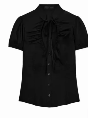 Svart blus med puffärm och knyt - Trendig svart blus med puffärmar och knytband vid halsen. 