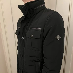 J.Lindeberg field jacket - En riktig snygg och trendig J.lindberg field jacket i topp skick, storlek M. Denna fieldjacka är en tjockare modell och är lika varm som en dunjacka vilket är perfekt inför vintern och sena hösten! vid frågor är de bara att skriva! 