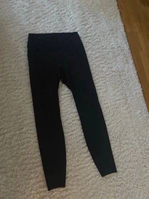 Svarta höga leggings - Säljer ett par svarta leggings med hög midja och lång benlängd. De är tighta och stretchiga, perfekta för en avslappnad och snygg look. Passar till många olika stilar och är riktigt bekväma.