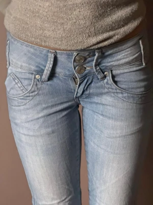 Ljusblå skinny jeans med dubbla knappar - Säljer ett par ljusblå lågmidjade skinny jeans ifrån Gina jeans, med dubbla knappar. Jeansen har en tight passform, stl 25/32.🤍🤍🤍 vid intresse hör av er! Obs köparen står för frakten.😊