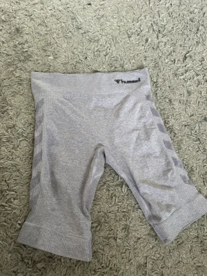 Ljus lila seamless cykelbyxor från Hummel - Säljer ett par ljus lila seamless cykelbyxor från Hummel med diskreta mönster längs sidorna och logga i midjan. Materialet är stretchigt och mjukt, perfekt för träning eller chill. Midjan är bred och bekväm för extra support.
