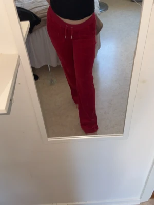 Röda Juicy byxor  - Säljer ett par snygga röda Juicy byxor, perfekt för chill dagar hemma eller när du vill vara bekväm men ändå se fräsch ut.