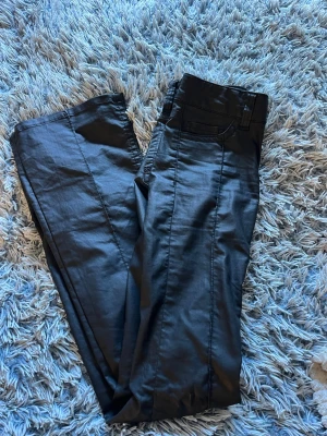 Skinbyxor från Nelly - Fina svarta skinnbyxor med sömmar på bakfickorna, använda 1 gång satt de är i fint skick. Storlek xs/34 