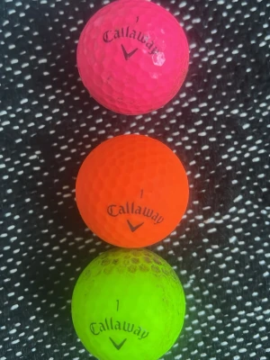 Färgglada golfbollar från Callaway - Tre golfbollar från Callaway i neonfärger: en rosa, en orange och en grön. Alla bollar har Callaway-loggan och siffran 1 tryckt på sig. Perfekta för dig som vill sticka ut på golfbanan och lätt hitta dina bollar.