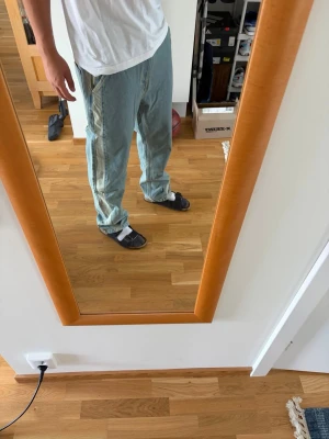 Baggy ljusblå jeans med raka ben - Säljer ett par baggy ljusblå jeans med raka ben och klassiska fem fickor. Jeansen har en avslappnad passform och är tillverkade i denim. Perfekta för en chill och trendig look. Storlek: 32/32. 