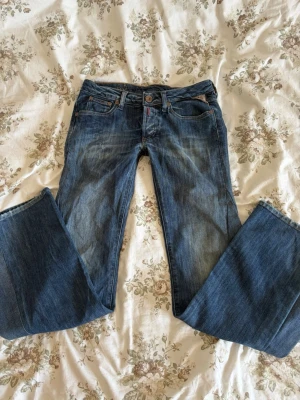 Blå bootcut jeans från replay - Säljer ett par blå bootcut jeans från replay. Jeansen har fem fickor, snygga slitningar och kontrastsömmar. Tillverkade i slitstark denim med en cool vintagekänsla. Perfekta nu till hösten🍁storleken är W27 L32.Skickar inom 1-2 dagar!