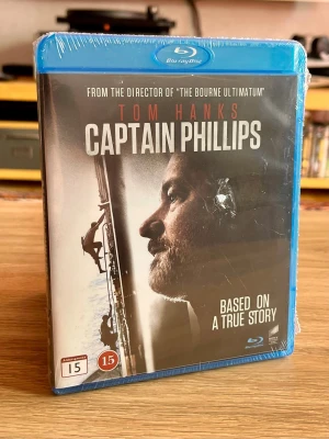 Captain Phillips – Blu-ray – ny och inplastad - Säljer Captain Phillips (2013) på Blu-ray med Tom Hanks i huvudrollen, regisserad av Paul Greengrass (The Bourne Ultimatum).  En intensiv och verklighetsbaserad thriller om kapningen av det amerikanska containerfartyget Maersk Alabama – och en av Tom Hanks starkaste prestationer.  Detta exemplar är fortfarande fabriksinplastat och oöppnat – perfekt för filmsamlaren eller dig som vill ha filmen i nyskick. 🎬  Skick: Ny / oöppnad / inplastad Format: Blu-ray Nordisk utgåva: Sony Pictures