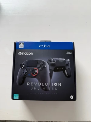 Nacon Revolution Unlimited Pro Controller - Ny skick använd fåtalgånger! Ny pris ligger på 1590kr och mitt pris 500kr ! Säljer en Nacon Revolution Unlimited Pro Controller för PS4. Handkontrollen är svart med röda detaljer, har ergonomisk form och flera knappar för avancerad gaming. Trådlös och trådad anslutning, medföljande USB-dongel och kabel. Perfekt för dig som vill ta ditt spelande till nästa nivå.  