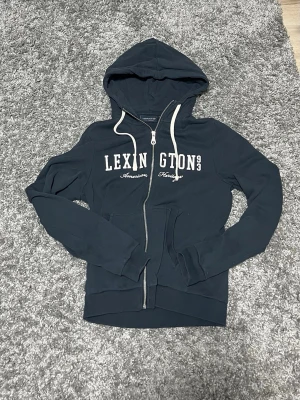 Lexington zip-hoodie - Mörkblå zip-hoodie från lexington i storleken S. Väldigt fint skick inga defekter. Säljes för att jag har växt ur den. Hör av er vid frågor eller funderingar😊