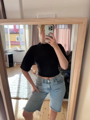 Tie back tee - Gina Tricot -  Croppad t-shirt med knytdetalj i ryggen. T-shirten är vit och har kort ärm. Den har hög halsringning och normal passform. Använd en gång