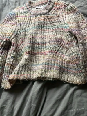 Pastellfärgad stickad tröja ONLY - Mysig stickad tröja från ONLY i storlek XS. Tröjan har en grovstickad struktur och är i flera pastellfärger som rosa, lila, blått och grönt. Rund halsringning och avslappnad passform. Perfekt för dig som gillar färg och vill ha något unikt i garderoben.