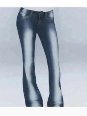 Mörkblå bootcut jeans med slitningar - Säljer ett par mörkblå bootcut jeans med snygga slitningar och ljusa tvättade partier framtill och baktill. Jeansen har klassisk femficksmodell och låg midja. Materialet är denim i bomull. Perfekta för en avslappnad och trendig look.