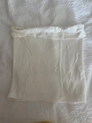 Vit bandeau tubtopp från Anbar - Säljer en enkel och stilren vit bandeau tubtopp från Anbar. Toppen är ärmlös och axelbandslös, perfekt för varma dagar eller som layering-piece. Mjuk och stretchig känsla i materialet för en bekväm passform.
