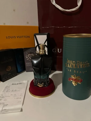 Jean Paul Gaultier Le Beau Le Parfum - Jean Paul Gaultier Le Beau Le Parfum är en herrparfym i en unik flaska formad som en manlig torso i svart och turkost glas med gulddetaljer. Kommer i en grön cylinderförpackning med guldtext. DE MER ÄN HÄLFTEN KVAR 65-70% KVAR I FLASKAN!