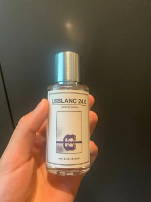 Parfymduo från One Bold Chemist - Två exklusiva parfymer från One Bold Chemist: LEBLANC 24.0 med silverfärgat lock och modern etikett med lila motiv, samt ALTMAN 22.0 med liknande design och orange motiv. Båda flaskorna är cylinderformade i genomskinligt glas och har stilrena etiketter.