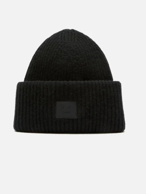 Svart acne mössa - Säljer en svart ribbstickad mössa med uppvikt kant och diskret patch framtill. Klassisk och enkel design som passar till det mesta. Perfekt för kalla dagar och ger en clean look.