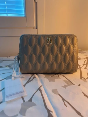 Tommy Hilfiger toiletry/makeup bag 🤎 - Unused with tags  Tommy Hilfiger "Refined Vanity Case" (toiletry/makeup bag) in beige, with tags attached. Purchased from Zalando; original price €85. Material: Outer material: Polyurethane Lining: Textile Material texture: Faux leather  Dimensions: Length: 20 cm Width: 4 cm Height: 15 cm
