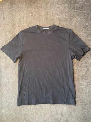 T-shirt från Zara - Säljer en klassisk svart T-shirt från Zara. Enkel och stilren design som passar till allt – perfekt som basplagg i garderoben. Bekväm passform och lätt att matcha med jeans, shorts eller cargo.  • Märke: Zara • Färg: Svart • Modell: Basic T-shirt • Skick: Bra använt skick, utan större defekter. • Perfekt till både vardag och streetwear.  📦 Skickas snabbt och väl paketerat. Hör gärna av dig om du vill ha fler bilder eller mått!