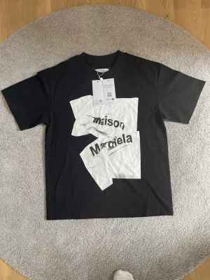 Äkta Marison Margiela t-shirt - Säljer en äkta maison margiela T-shirt som är helt ny och oanvänd. Den är i storlek M