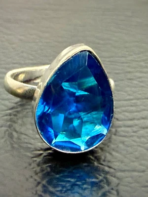 Handgjord Exklusiv Statementring 925 Sterling Silver m Stor Syntetisk Safir Unikt Hantverk  - Exklusiv handgjord statementring i äkta 925 silver med stor blå syntetisk safir. Skapad av en kvinnlig silversmed som arbetar småskaligt med unika smycken där varje sten väljs ut och infattas med omsorg. Safiren symboliserar traditionellt visdom, styrka och lugn. Ny och oanvänd, stämplad 925. Justerbar storlek (innerdiameter ca 20 mm ojusterad). Priset är redan lågt för en så gedigen och glamorös ring, så jag prutar inte. Däremot erbjuder jag bundlerabatt vid köp av flera föremål.