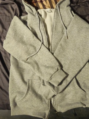 Grå hoodie från Burberry med dragkedja - Fet grå hoodie från burberry den är helt ny och är oanvänd. Kan säljas billigare vid snabb affär. Bara att höra av sig vid frågor och kan lösa fler bilder vid önskning.