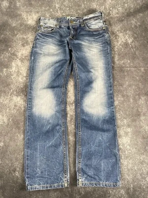 Blå M.O.D-vintagejeans för herrar i storlek W31 L32 - Snygg tvätt och bekvämt slitet denim.  Skick: 9,5/10  Midja: 41 cm Benslut: 20 cm Lår: 31 cm Totallängd: 101 cm Måtten finns även på bilderna  Skickas inom ett dygn På min profil finns fler jeans