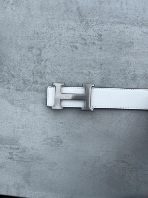 Vitt Herme’s bälte  - Ett vitt Herme’s bälte med silverfärgat spänne. Ett sjukt snyggt bälte som passar till både vardags och finare outfits.