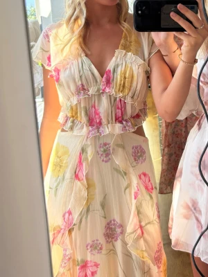 Blommig långklänning med volanger - Säljer den perfekta sommarklänningen ifrån Zara. Använd 1 gång på midsommar i år! Suuuuper fin lång klänning med en slits( skriv för mer bilder)💅🥰💕🌸