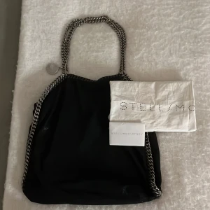 Stella McCartney - Säljer den här super snygga Stella McCartney väskan, den är använd bara några få gånger och är köpt av en annan här på plick❤️Väskan är i bra skick och har inga defekter bara lite längst ner på kedjan som man kan se på bild 2, men det är Inget som märks💕 skriv gärna om frågor eller fler bilder❤️pris går att diskutera 