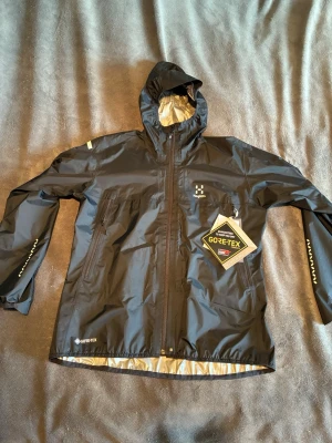 Haglöfs Regnjacka Gore-Tex  - Lätt och tunn regnjacka från Haglöfs med Gore-Tex | Storlek: XL | Helt nya | skriv vid frågor | Nypris 3100kr | Färg: Svart | Finns även i Stl,S i min profil |