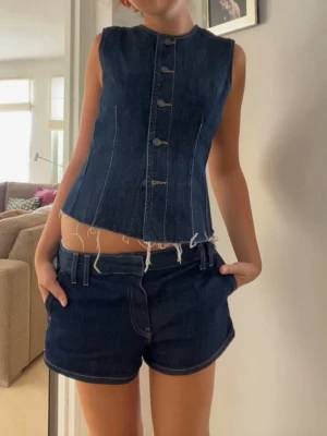 Jeanstopp - Supersnygg topp/väst med jeansmaterial och knappar! Samma collection som shortsen på bilderna, uuuursnyggt! Kommer tyvärr inte till användning och därför säljer jag toppen💞💞💞🙏🏼🙏🏼
