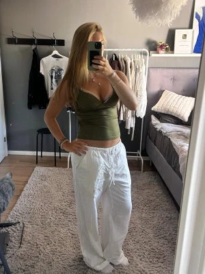 Vita vida linnebyxor med dragsko - Säljer ett par vita, luftiga linnebyxor med avslappnad passform och snöre i midjan. Byxorna har raka ben och är perfekta för en chill och stilren look. Passar till både crop tops och linnen för en fräsch sommarstil. Dom är jättelånga på mig som är 164cm.