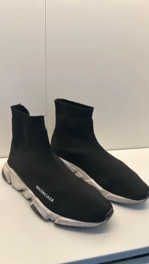  Speed Trainer svarta sneakers - Svarta  Speed Trainer sneakers med stickad ovandel i textil och vit chunky sula. Strumpliknande passform och logga på sidan. Perfekta för dig som gillar streetwear och vill ha en clean look.