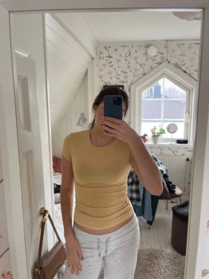 Gul tight t-shirt  - En enkel gul t-shirt med rund hals och korta ärmar. Modellen är tight och sitter fint på kroppen. Super skönt material från ginas soft touch kollektion!