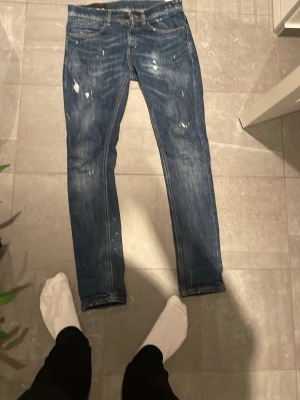 Dondup jeans - Säljer ett par blå jeans med coola slitningar och orange kontrastsömmar. Klassisk femficksmodell med normal passform och raka ben. Perfekta till vardagslooken och riktigt snygga detaljer baktill. Modell George