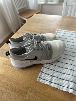 Vita Nike golfskor - Snygga vita Nike golfskor i storlek 44. Skorna har lågt skaft, snörning och ovandel i mesh och syntetmaterial för bra andningsförmåga. Tjock vit sula ger skön dämpning. Säljer då dem är lite för små. 