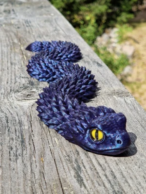 Ledad flexiorm 36 cm - Ledad Flexiorm Glittrande blå kameleontfärg med gula ögon. Längd: 36 cm. Material PLA. Kroppen är böjlig och detaljerad, perfekt som prydnad eller leksak.