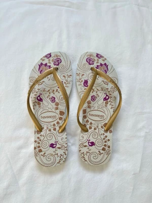 Havaianas - Havaianas med guldfärgade remmar och fin mönster. Väldigt bra skick, Vid köp av flera varor får du rabatt 💛