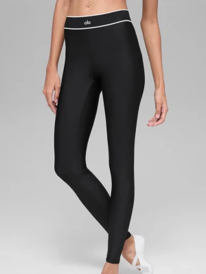 Svarta leggings från Alo Yoga - Snygga svarta leggings från Alo Yoga med hög midja och vit kontrastkant upptill. Tillverkade i ett stretchigt och glansigt material som sitter tight och bekvämt. Perfekta för träning eller chill. Diskret logga på midjan och benet.