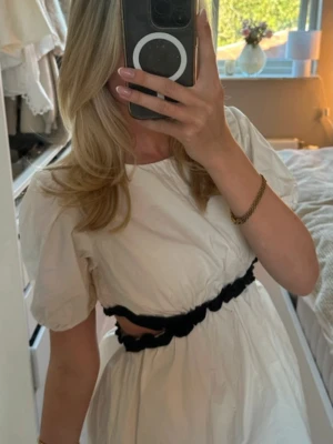 Vit populär Zara klänning med cut out - Väldigt populär Zara klänning, i barnstorlek 12-13 år men sitter som en xs/ liten S. Lite smink på ärmen som kan kanske kan få bort i tvätten men syns inte jätte mycket 
