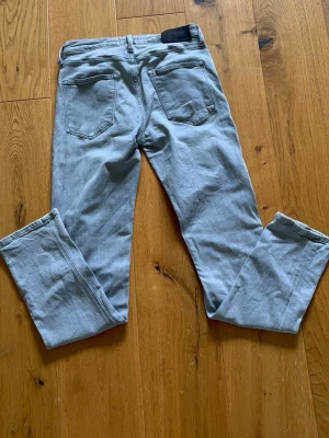 Grå Jack n Jones jeans - Säljer ett par gråa jeans med rak passform. Jeansen har bälteshällor. Perfekta för en avslappnad och trendig look. Strlk w28 L32
