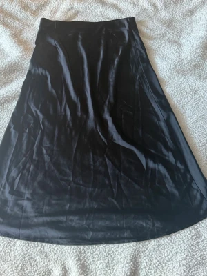 Svart satinkjol med spetskant - Kjol i satin gått sönder vid midjan men är inuti då det ej finns utanför. 