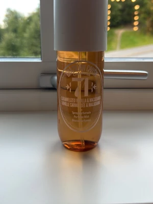 Parfymmist Caramelized Vanilla & Macadamia - En parfymmist i en genomskinlig, bärnstensfärgad plastflaska med vit kork. Doften är Caramelized Vanilla & Macadamia och flaskan har en modern, stilren design med tryckt text i vitt. Perfekt för dig som gillar söta och nötiga doftnoter.